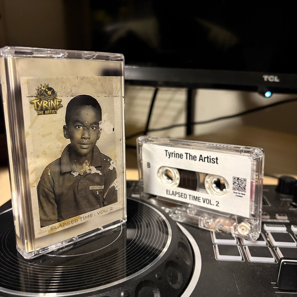 A clear plastic cassette case with a printed cover photo and the text 'Tyrine The Artist' and 'Elapsed Time Vol. 2' sits beside a clear cassette tape labeled 'Tyrine The Artist' and 'Elapsed Time Vol.